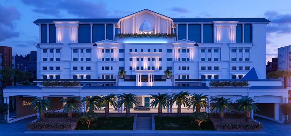 Luxury hotel exterior featuring white classical architecture with illuminated columns and palm trees at twilight