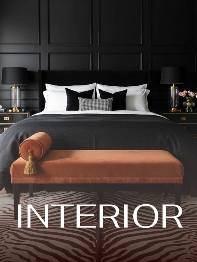 A luxurious bedroom with a dramatic black paneled wall behind a large bed with white linens, black throw pillows, and a patterned lumbar pillow. An orange velvet bench with tassel detail sits at the foot of the bed on a zebra-print rug. Gold-accented black nightstands with lamps are on either side of the bed. The word "INTERIOR" is overlaid in large white sans-serif letters in the foreground.